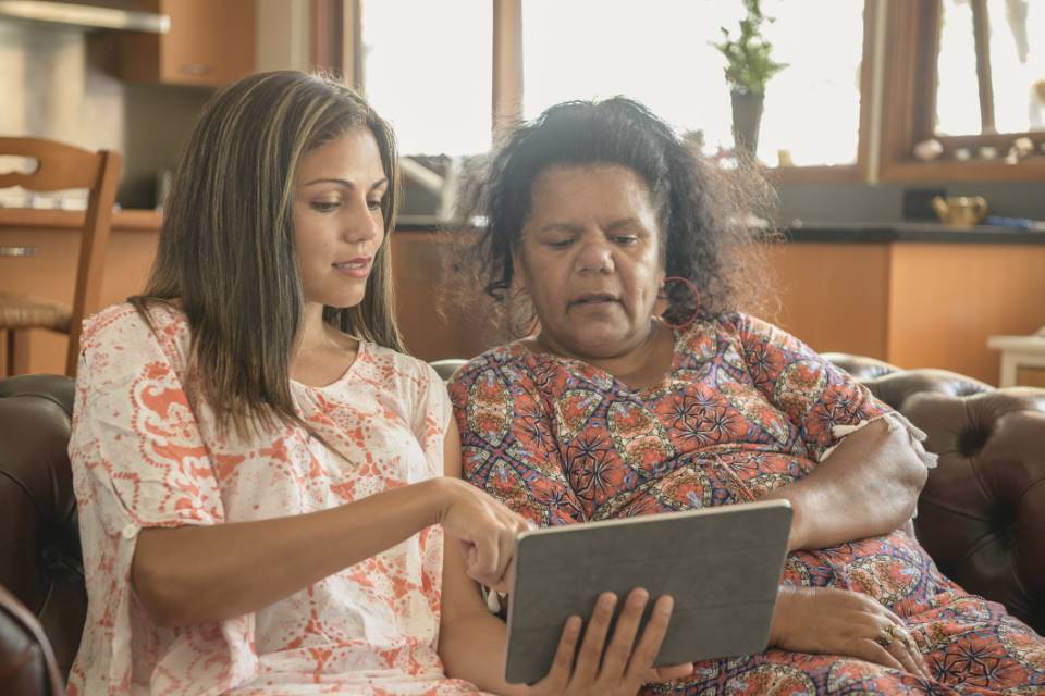 Two Aboriginal women using digital tablet